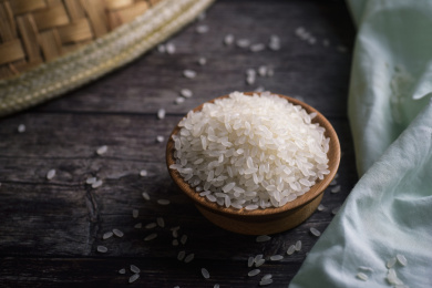 一碟大米和黄色草帽在木质背景板上