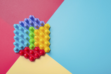 红黄蓝背景的多个彩色螺栓拼成的对称六边形结构