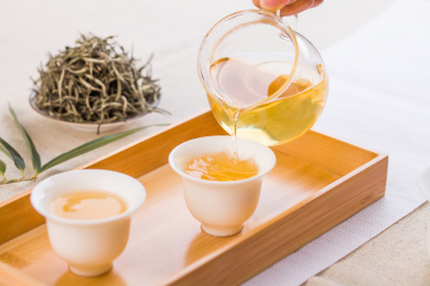 中式茶席上木托盘里的白瓷杯里的茶汤