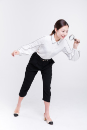 年轻女士手拿放大镜观察探索