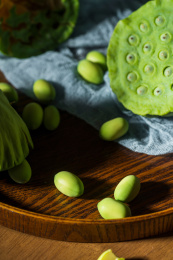 松木托盘里的新鲜莲蓬头和莲子