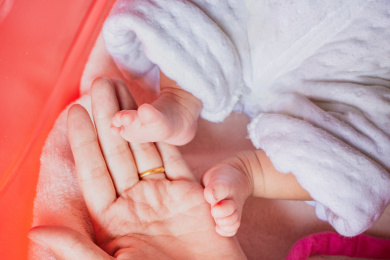 妈妈用手托住新生婴儿的两只小脚丫