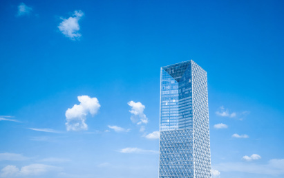 一栋孤立的现代高层建筑耸立在蓝天白云中