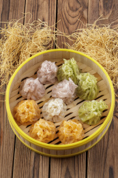 笼屉装的刚出炉的三色烧麦摆放在木板上