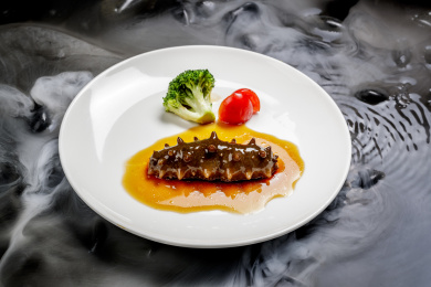 鲍汁扣辽参摆放在干冰缭绕的水中