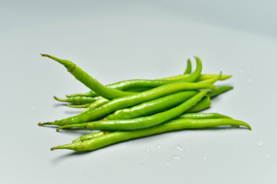 一堆绿色的辣椒尖椒的摆放在灰色背景上