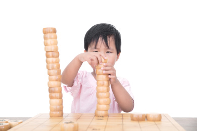 中国三岁小女孩在兴致勃勃的摆弄中国象棋棋子