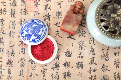 俯视拍摄书桌上铺开的书法作品和篆刻印章及打开的印泥盒