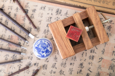 俯视拍摄固定在刻床上的印章和被一圈刻刀围绕的印泥