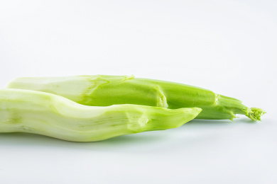 两根削皮的粗芥蓝杆在白背景上