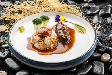 鲜鲍鱼辽参捞饭摆放在黑色鹅卵石上