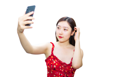 夏季一个中国女孩拿着手机正在自拍拍照