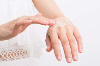 女性涂抹化妆品、乳液到她的手上，化妆品概念