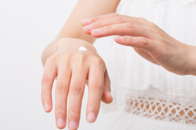 女性涂抹化妆品、乳液到她的手上，化妆品概念