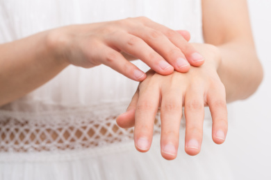 女性涂抹化妆品、乳液到她的手上，化妆品概念