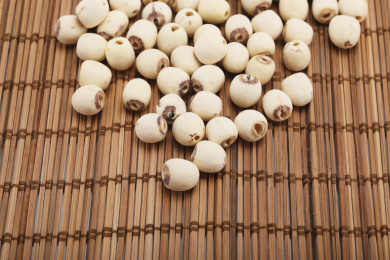 一堆干莲子放在编织桌面上