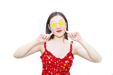 一个中国美女站在白色背景下戴着柠檬的眼睛