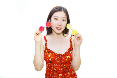 一个中国美女站在白色背景下挑选着柠檬和西瓜眼镜