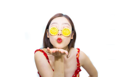 一个中国美女站在白色背景下戴着柠檬的眼睛