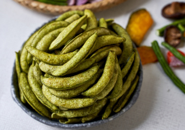 浅色背景下盘里的绿色豆角干