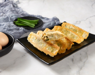 黑色盘子里金黄外皮的韭菜鸡蛋锅贴