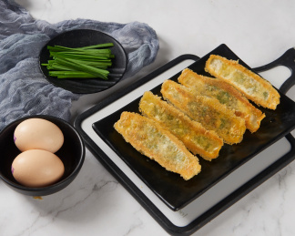 黑色盘子里金黄外皮的韭菜鸡蛋锅贴