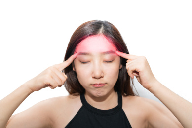 一个亚洲女人摸着自己的疼痛头痛头疼的脑袋,感觉很难受很烦躁