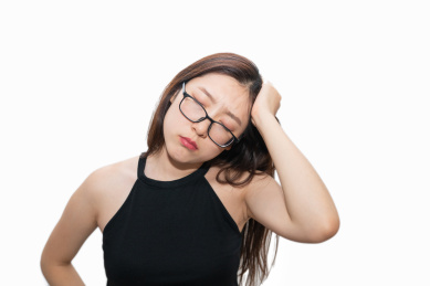 一个亚洲女人摸着自己的疼痛头痛头疼的脑袋,感觉很难受很烦躁