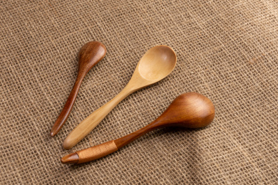 橙色粗麻布上的咖啡色和原木色木勺子