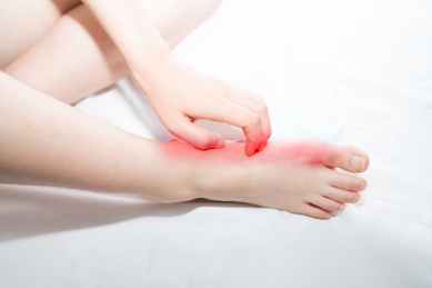 一个摸着挠着自己瘙痒疼痛痒痒红肿的脚气脚的人