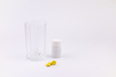 白色背景中放着的医疗药品和杯子