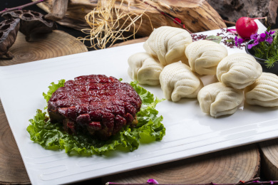 长方形瓷盘装的花馍夹酱肉摆放在樟木砧板上