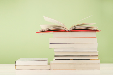 一堆书放在桌子上，纯色背景