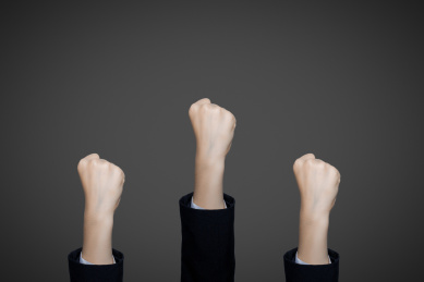 很多只握拳的手臂象征着商务合作团队合作齐心协力走向成功