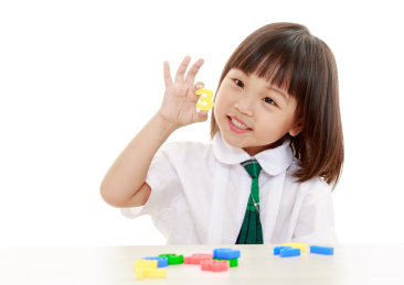 穿校服的小女孩开心的手拿着一个数字玩具