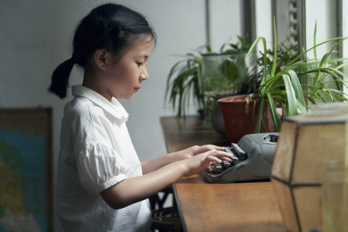 小女孩使用打字机学习写作