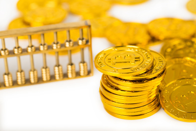 白色背景上无序摆放着的金币和金算盘