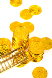 白色背景上无序摆放着的金币和金算盘