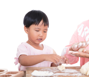 中国小孩子在跟着妈妈学习做中秋传统食品月饼