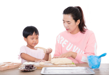 中国小女孩在跟着妈妈学习制作中国中秋节传统美食月饼