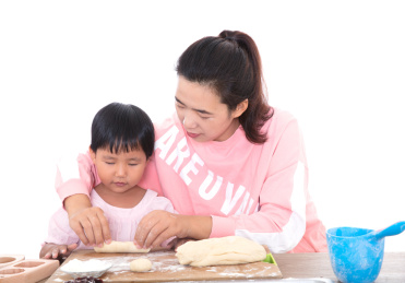中国年轻妈妈手把手教自己的孩子做月饼