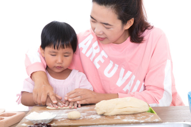 中国年轻妈妈手把手教自己的孩子做月饼