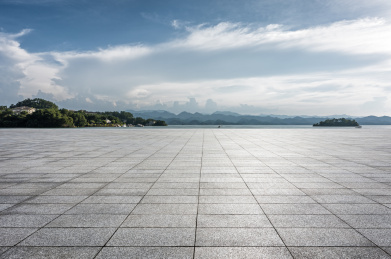阳光下的海滨风光和花岗岩道路地面
