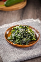 木盘子里盛着一份白芝麻凉拌海带片