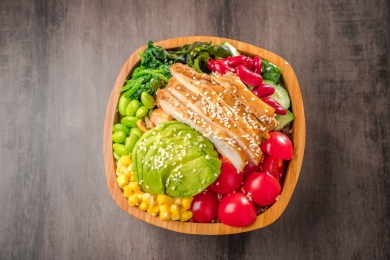 方形竹碗里盛着一份牛油果烤鸡胸拌饭