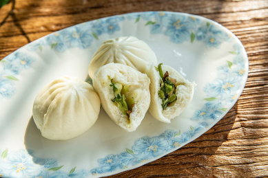 木桌面上的营养早餐一盘菜包子  