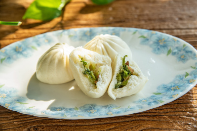 木桌面上的营养早餐一盘菜包子  