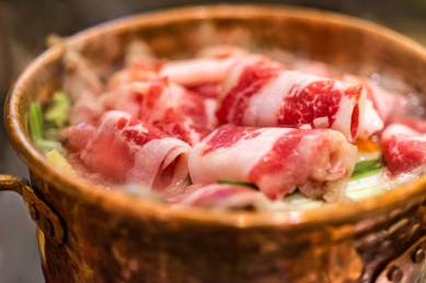 铜火锅内正在烹饪的雪花肥牛卷