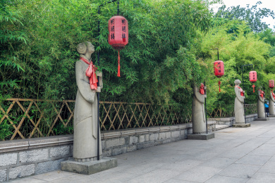 中国山东省济南市大明湖公园绿竹林前的一排举着红灯笼的古代侍女石雕像