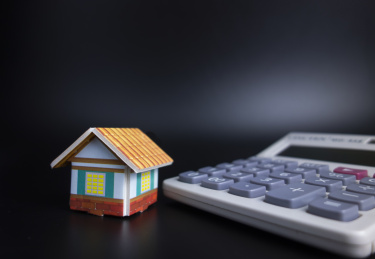 黑色背景中放着小房子和计算器